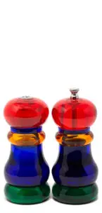 Two colorful glass pepper mills against a white background. Each has red tops, blue bodies, and orange accents, with one featuring a metal knob.