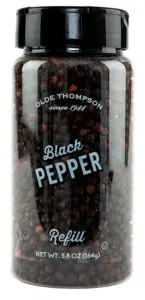 Clear plastic jar filled with whole black peppercorns. The label reads Olde Thompson since 1944 Black Pepper Refill and displays the weight as 5.8 oz (164g). The jar has a black lid.