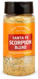 A bottle of Olde Thompsons Santa Fe Scorpion Blend seasoning. It features an orange label indicating a garlicky punch with lingering heat and is part of the American South West series. The net weight is 6.6 oz (187g).