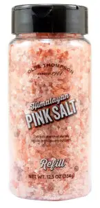 A clear plastic container of Olde Thompson Himalayan Pink Salt with a black lid. The label says since 1944 and This salt does not supply iodide, a necessary nutrient. The net weight is 12.5 oz (354g), marked as a refill.