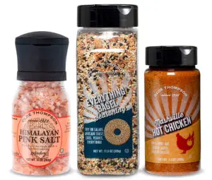 Three spice bottles: Himalayan Pink Salt in a grinder, Everything Bagel Seasoning, and Nashville Hot Chicken seasoning. All have the Olde Thompson brand label.