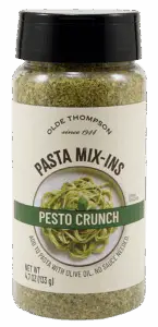 A jar of Olde Thompson Pasta Mix-Ins labeled Pesto Crunch, featuring an image of pesto pasta on the front. The jar contains 4.7 oz (133 g) of the pasta seasoning mix.